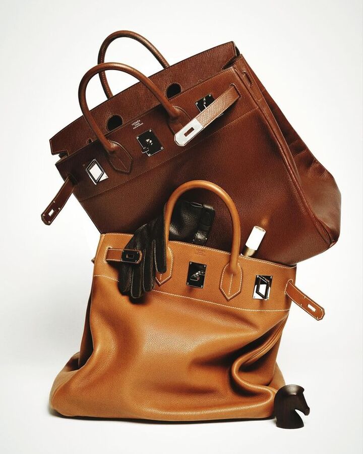 Two cognac leather bags stacked on a white backdrop