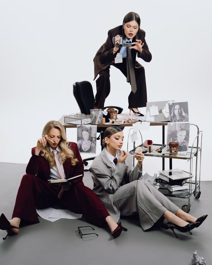 Editorial of three women in suiting around a cluttered office desk