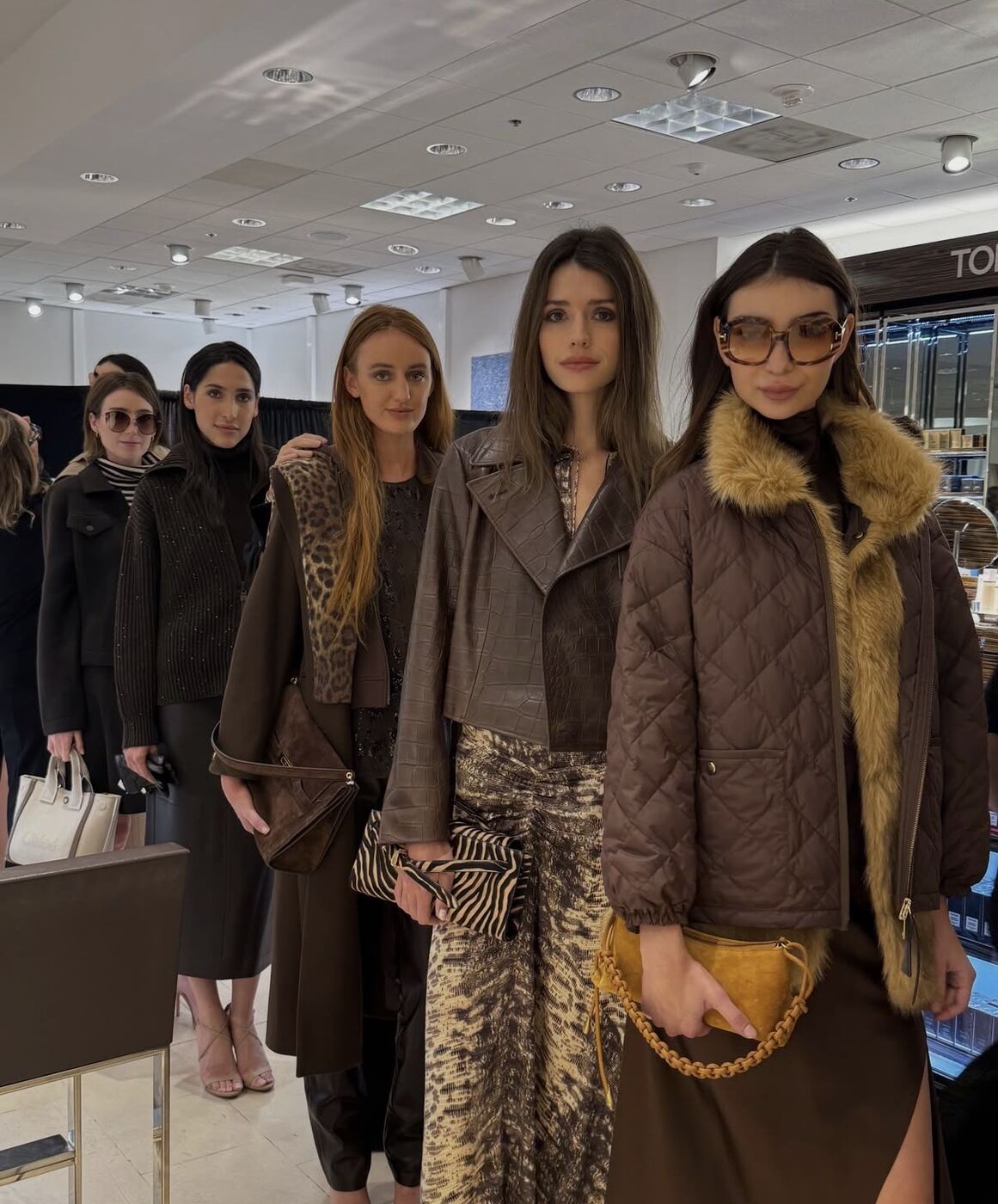 Models lined up backstage in fall looks before a Neiman Marcus show