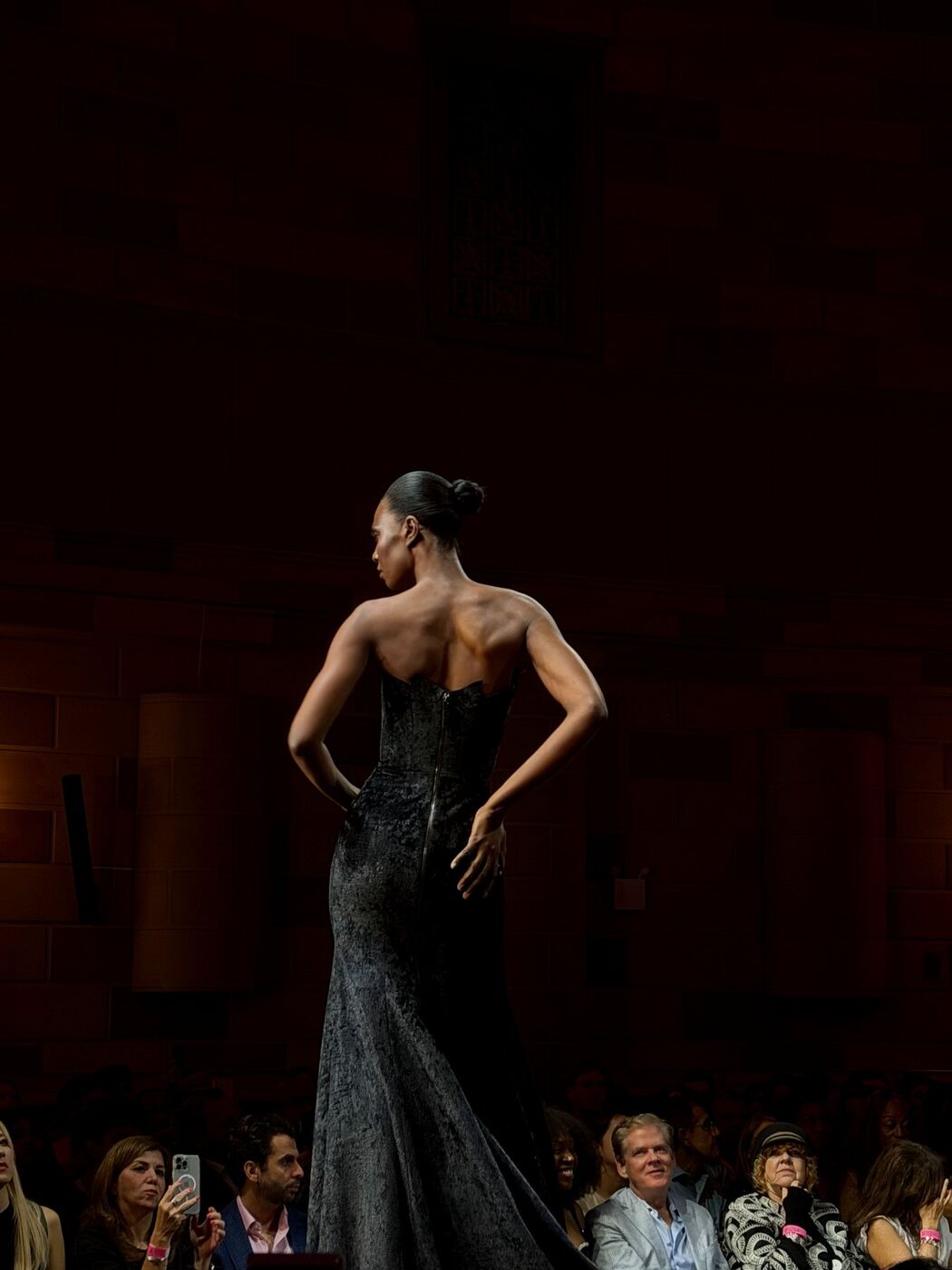 Model in a black beaded gown posing on the runway