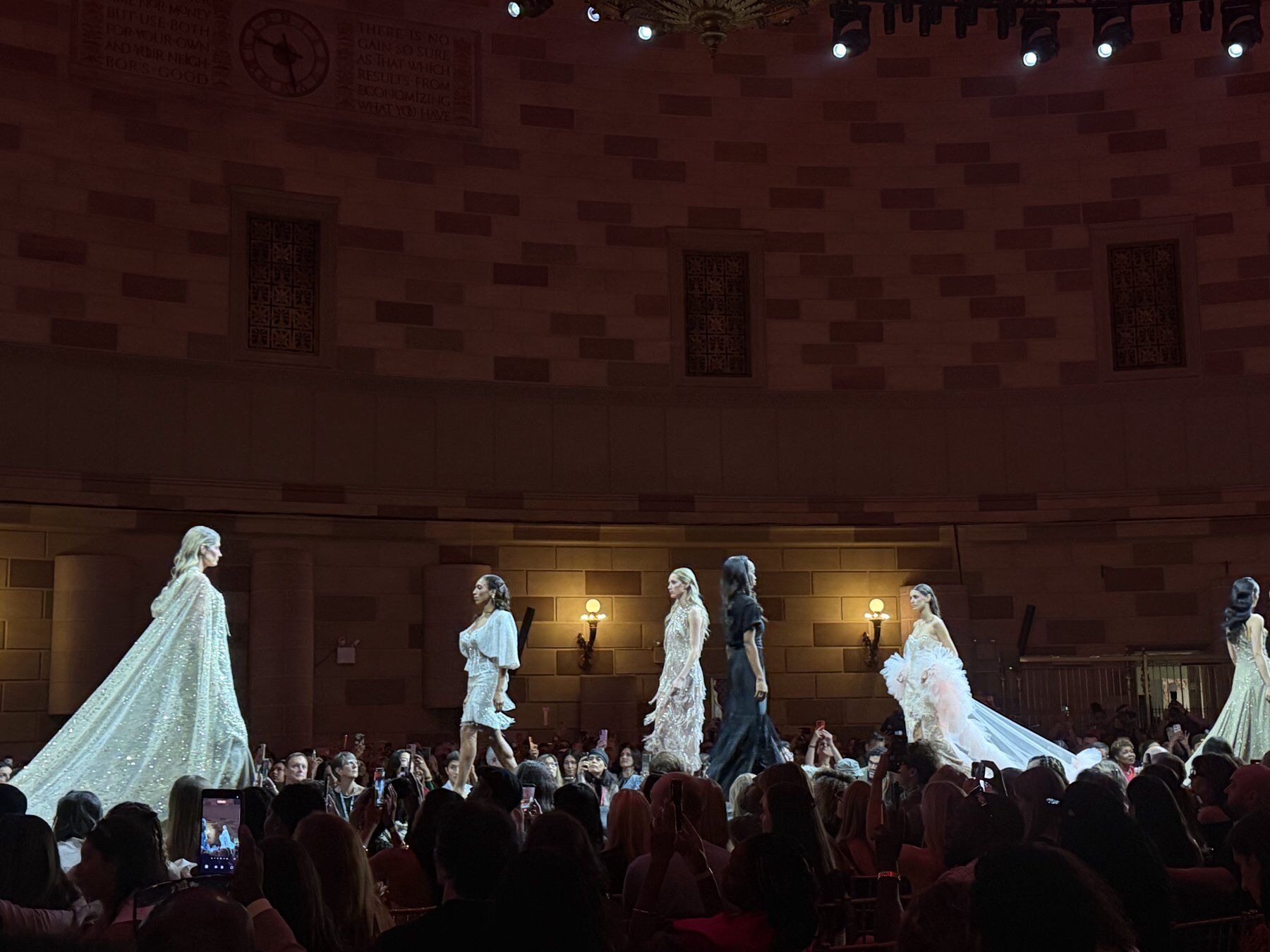 Finale of models in white bridal gowns walking past the audience