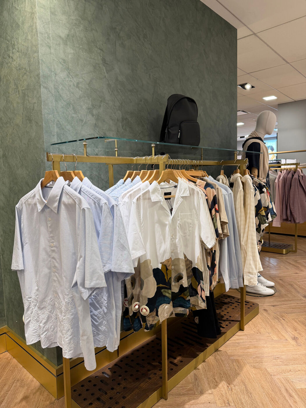 Ted Baker shirts merchandised on a gold rack