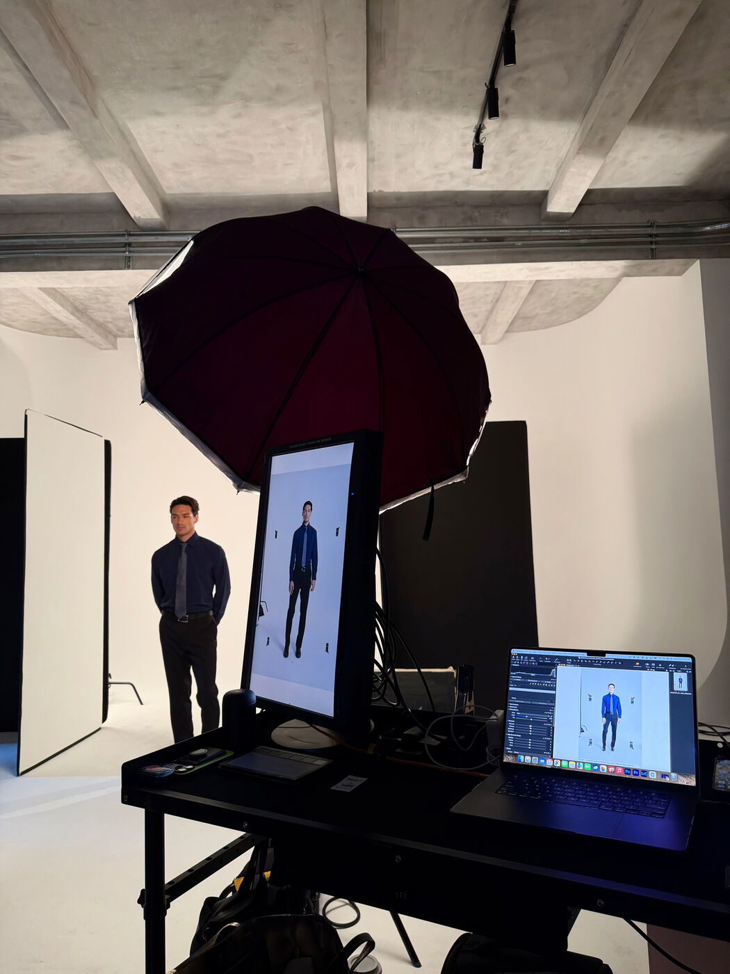 Studio setup with lighting and a tethered monitor showing the model