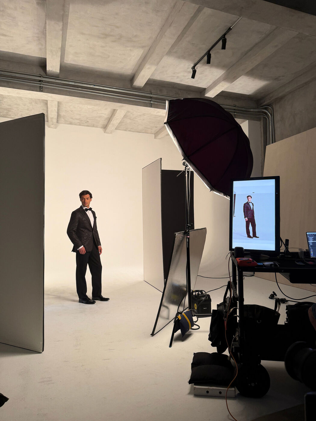 Model in a tuxedo on set between shots