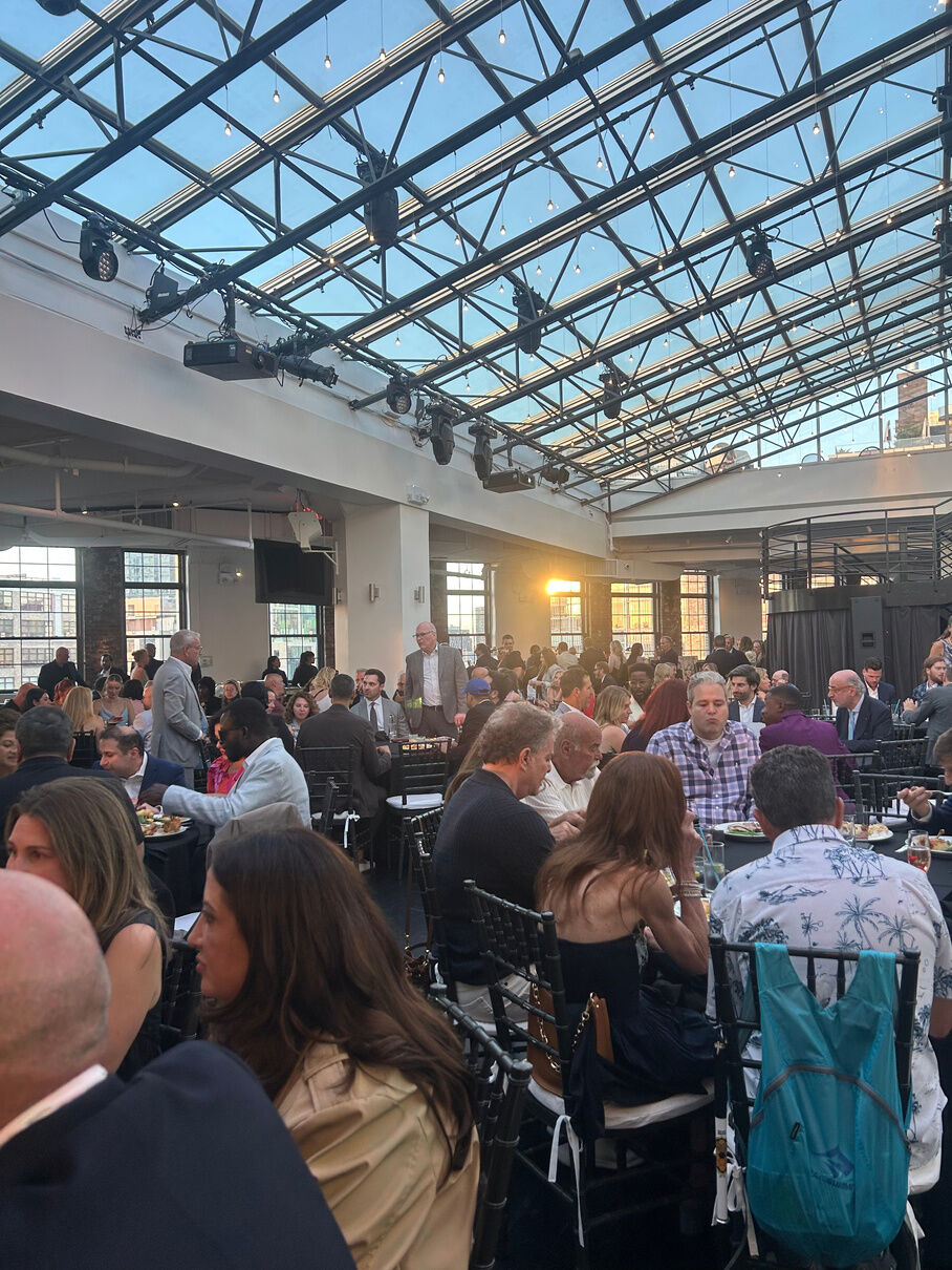 Guests at a charity luncheon under a glass atrium