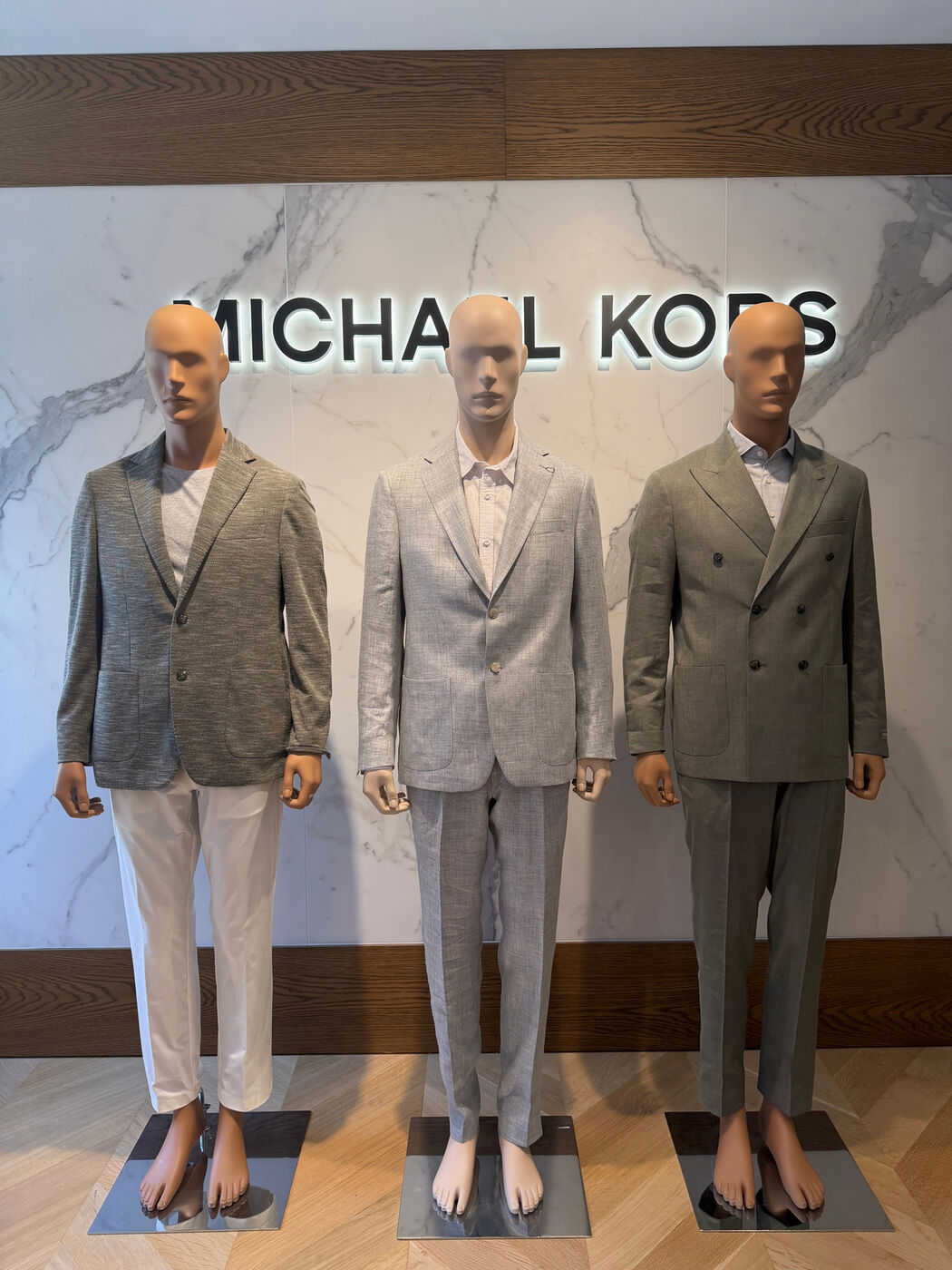 Three styled mannequins in Michael Kors suits