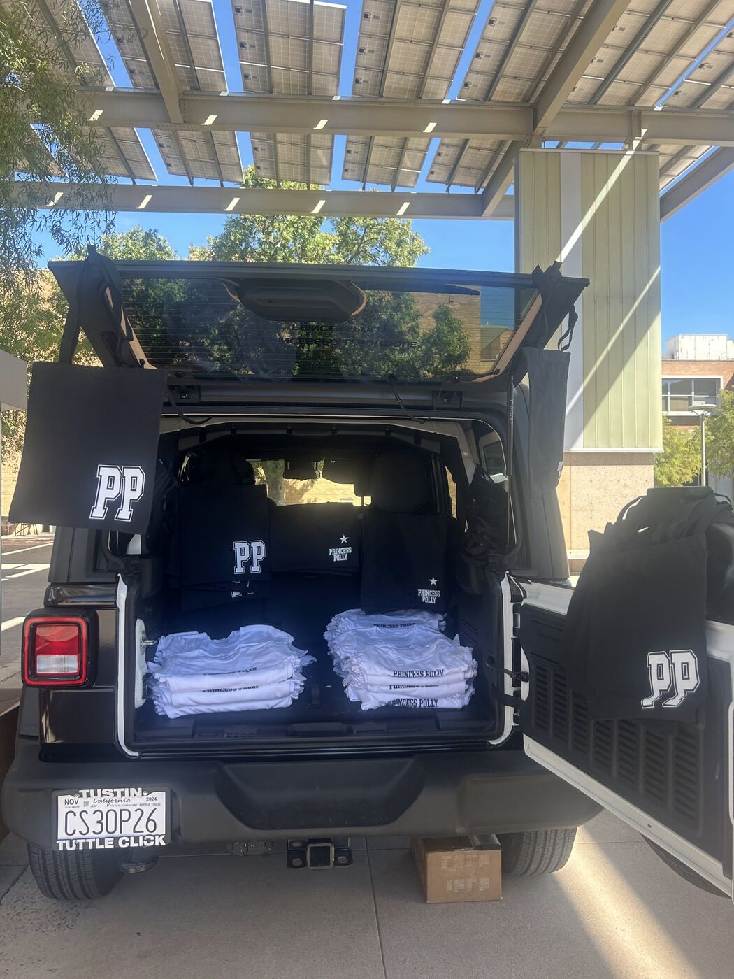 Jeep trunk stacked with folded Princess Polly tees for giveaways