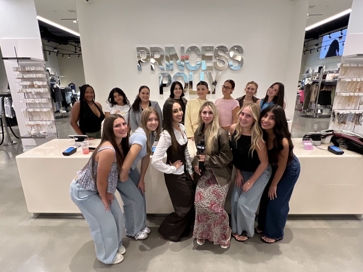 The Princess Polly Scottsdale team in front of the mirrored logo wall