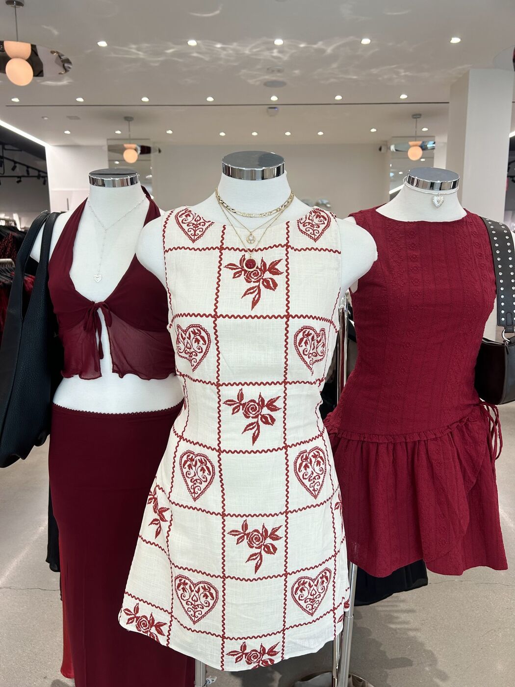 Three dress forms in red and cream heart-print looks