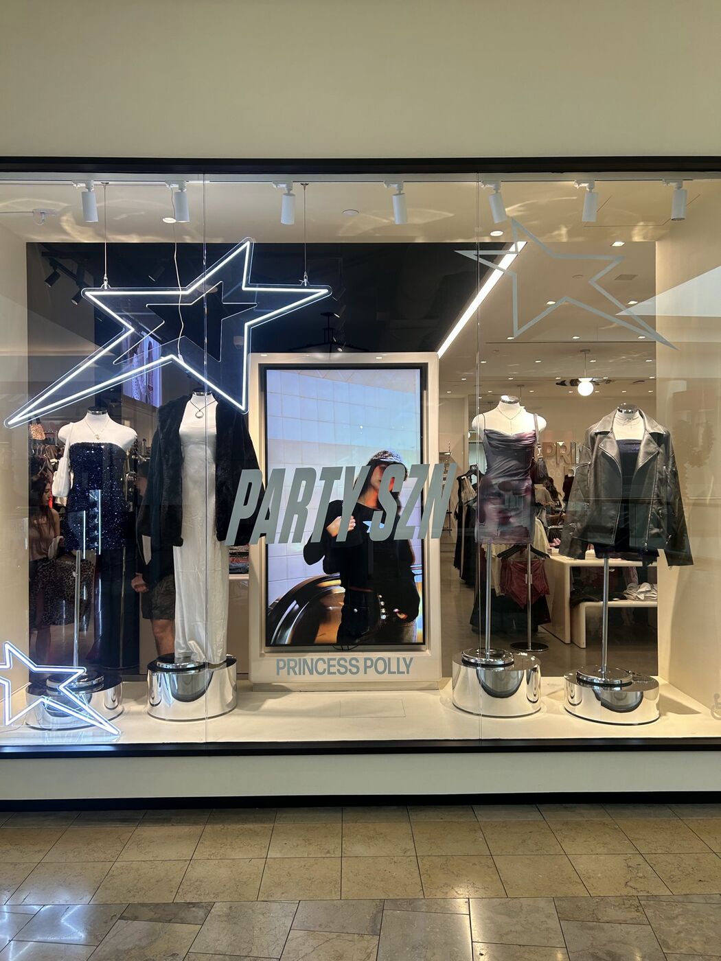 Princess Polly storefront window with neon stars and styled mannequins